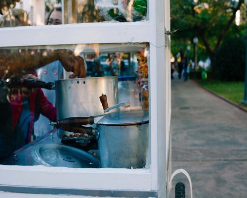 A clean street food cart displaying cooked food safely behind glass